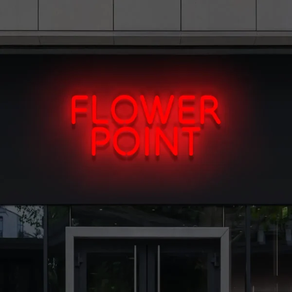 Czerwony napis LED Flower Point – intensywny neon reklamowy na budynku