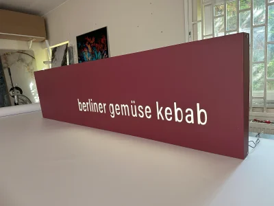 Czerwony kaseton z Dibondu – „berliner gemüse kebab”, podświetlane litery